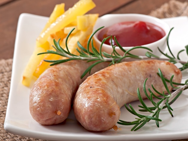 Free photo chicken sausages grilled with a side dish of  french fries