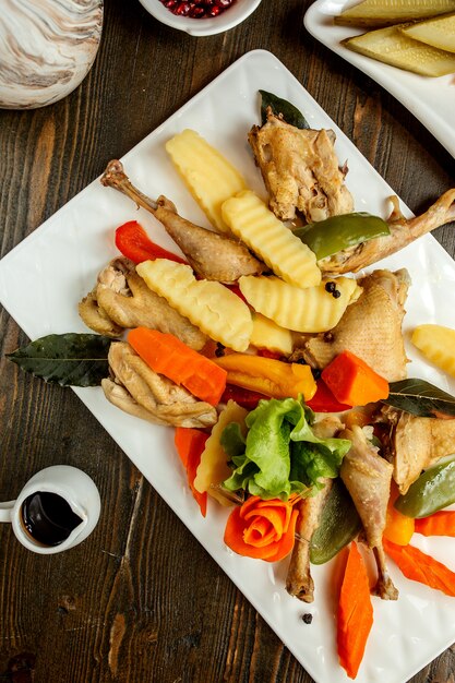 Chicken served with potatoes carrots and lettuce