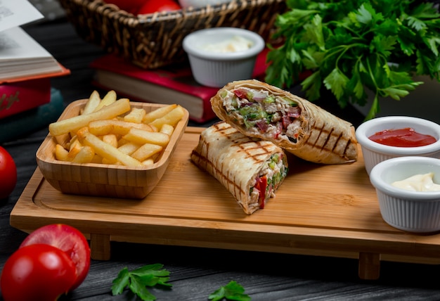 Free photo chicken shaurma, lavash stuffed with meat and vegetables served with dip sauces