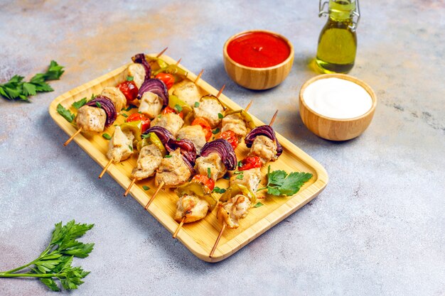 Chicken shish kebab with vegetables, ketchup, mayonnaise, top view