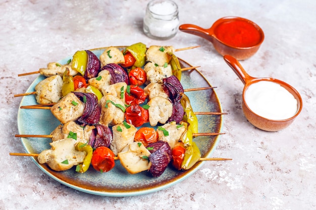 Free photo chicken shish kebab with vegetables, ketchup, mayonnaise, top view