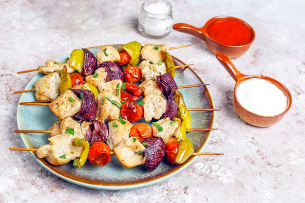 Chicken shish kebab with vegetables, ketchup, mayonnaise, top view