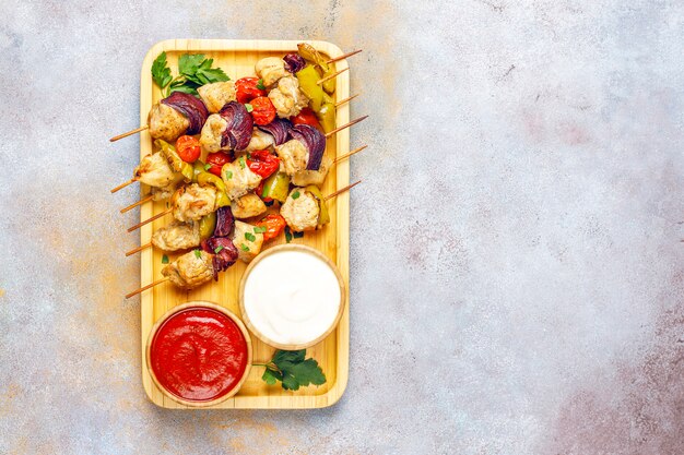 Chicken shish kebab with vegetables,ketchup,mayonnaise,top view