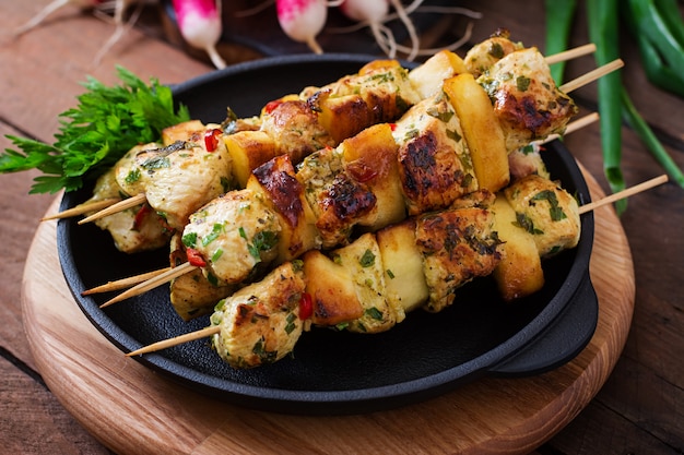 Foto gratuita spiedini di pollo con fettine di mele e peperoncino