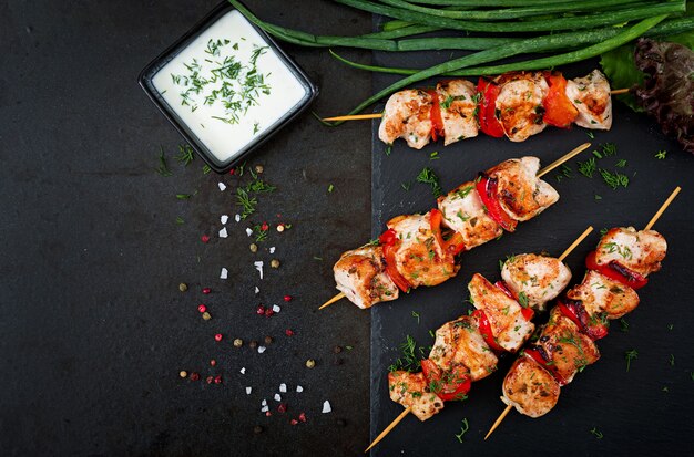 Chicken skewers with slices of sweet peppers and dill.