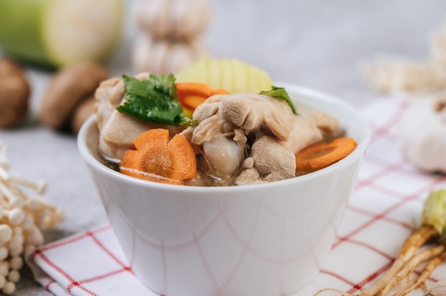 Chicken soup with corn, shiitake mushroom, enoki mushroom, and carrot.