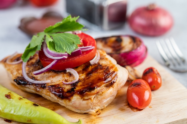 Chicken steak placed on a wooden tray.