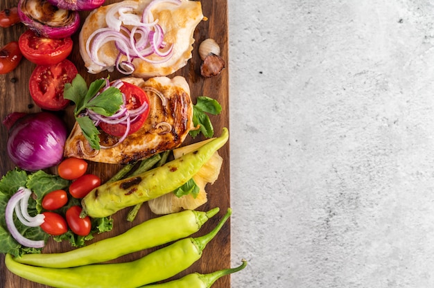 Foto gratuita bistecca di pollo disposta su un vassoio di legno.