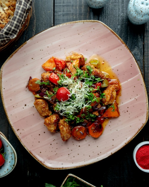 Chicken stew with vegetables garnished with herbs parmesan and tomato