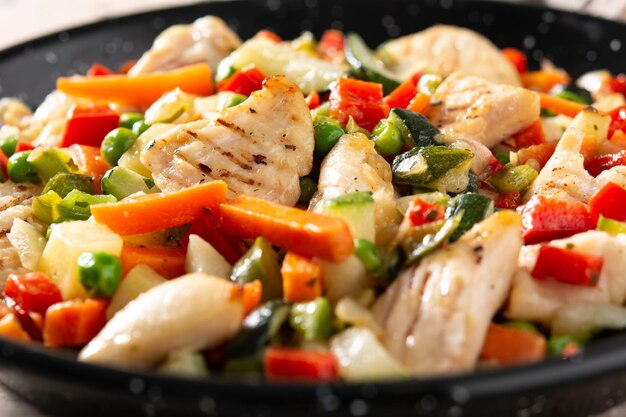 Chicken stir fry and vegetables on wooden table