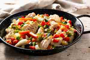 Free photo chicken stir fry and vegetables on wooden table