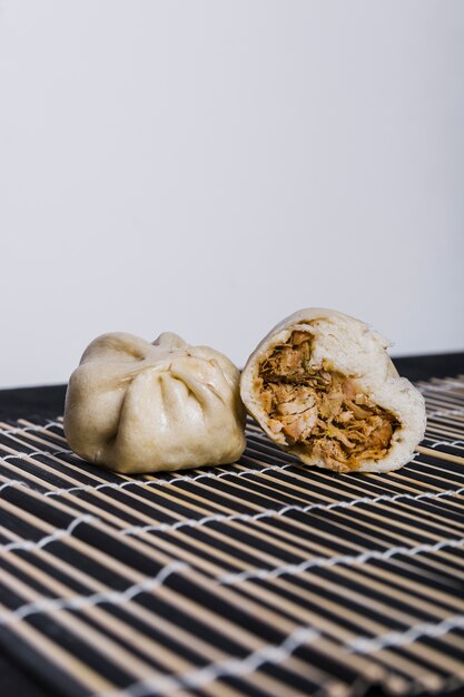 Chicken stuffed dumpling on placemat against white backdrop