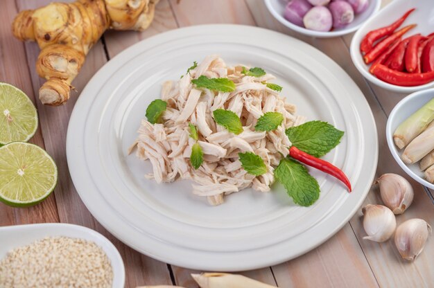 The chicken that is bordered is cooked and placed in a white plate along with mint leaves.