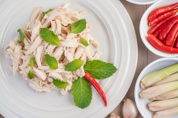 The chicken that is bordered is cooked and placed in a white plate along with mint leaves.