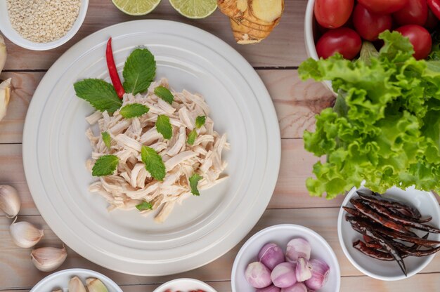 The chicken that is bordered is cooked and placed in a white plate along with mint leaves.