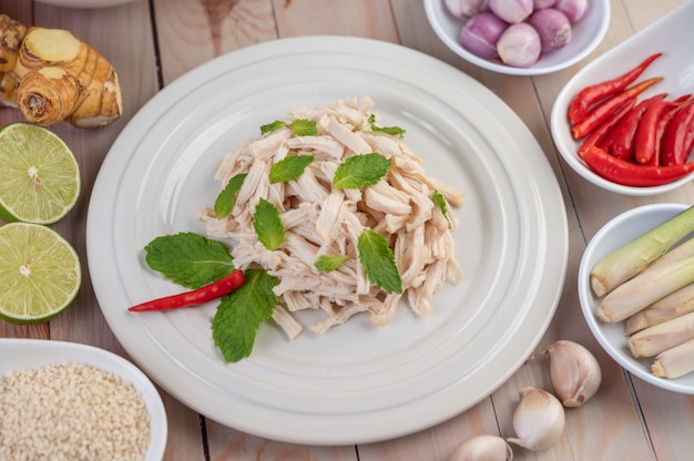 Free photo the chicken that is bordered is cooked and placed in a white plate along with mint leaves.