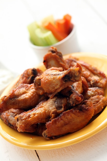 Chicken wings in bowl with vegetables