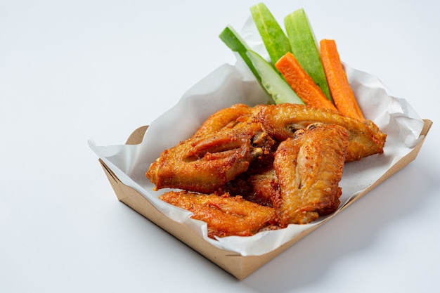 Chicken wings in paper box on a white