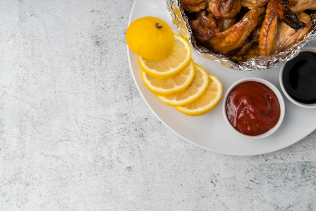 Ali di pollo con ketchup sulla tavola grigia