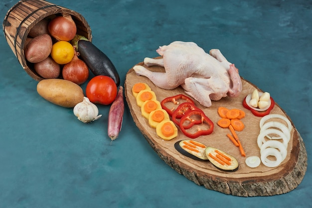 バケツに野菜を入れた木の板に鶏肉。
