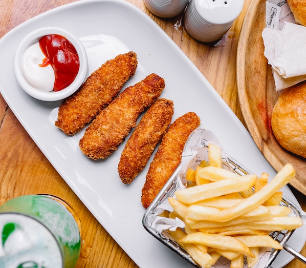 Chickensticks with french fries ketchup mayonnaise side view