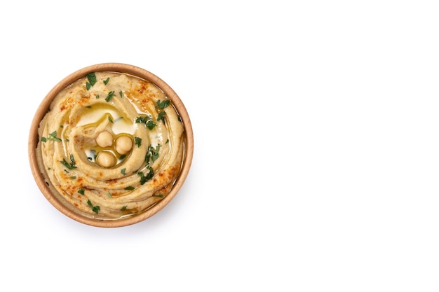 Chickpea hummus in a wooden bowl garnished with parsley paprika and olive oil