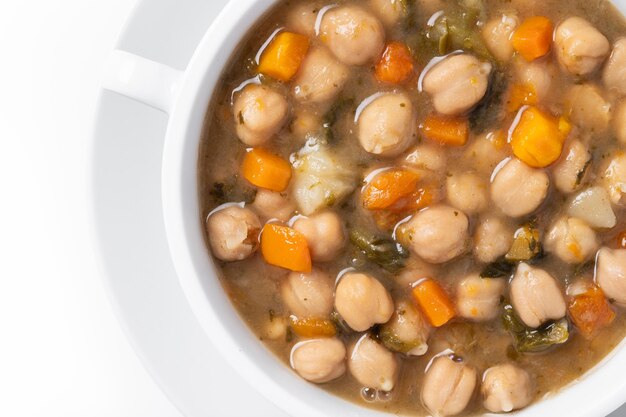 Chickpeas soup with vegetables in bowl isolated on white background Close up