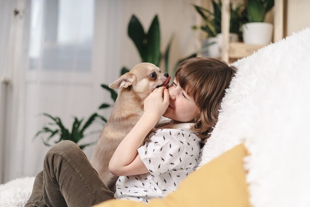 若い女の子の顔をなめる白いふわふわポメラニアン犬の肖像画 プレミアム写真 若い女の子の顔をなめる白いふわふわポメラニアン犬の肖像画 プレミアム写真