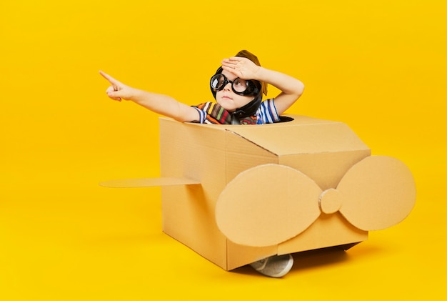 Child as astronaut in toy plane pointing