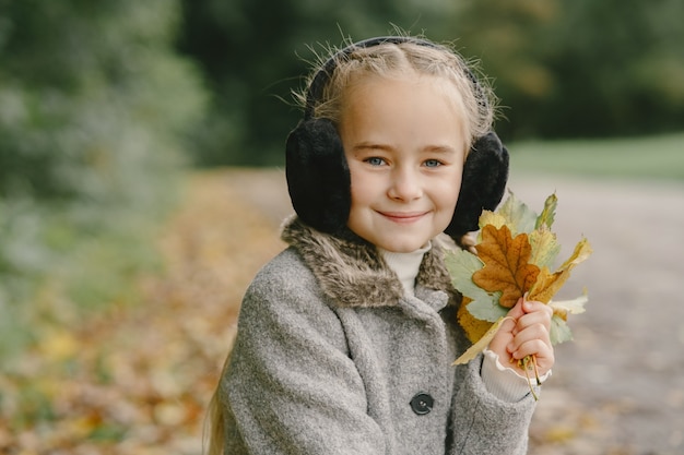 가을 공원에서 아이입니다. 회색 코트를 입은 아이.