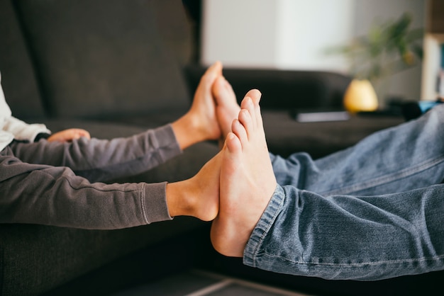 Piedi nudi del bambino che toccano i piedi del padre