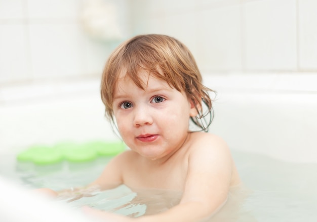 child bathes in bathtub