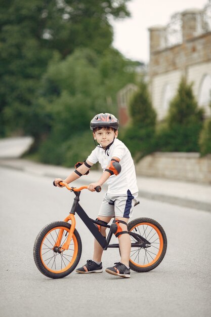 여름에 아스팔트 도로에서 자전거에 아이. 공원에서 자전거