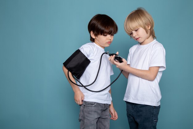 Child boys little cute adorable measuring pressure in white t-shirts and jeans