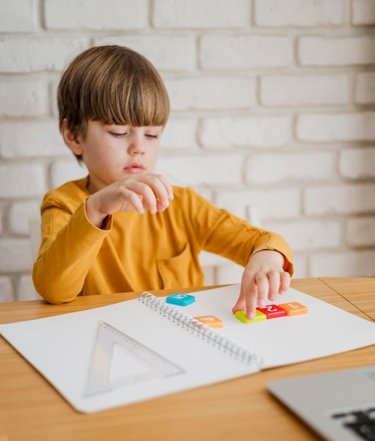 Foto gratuita il bambino alla scrivania è tutorato online