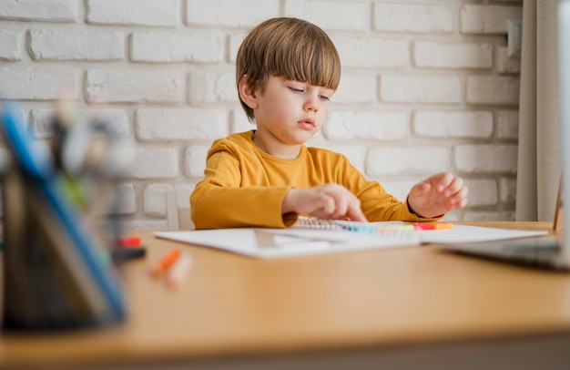 Il bambino alla scrivania viene istruito online