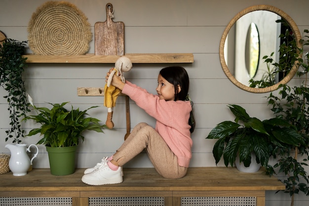 Foto gratuita bambino che fa attività domestiche al chiuso