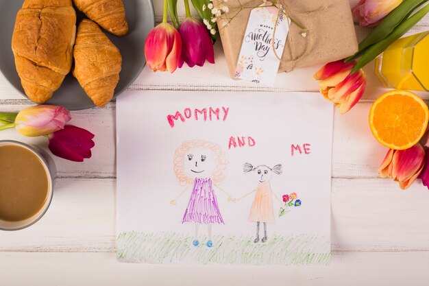 Child drawing around classic breakfast with flowers