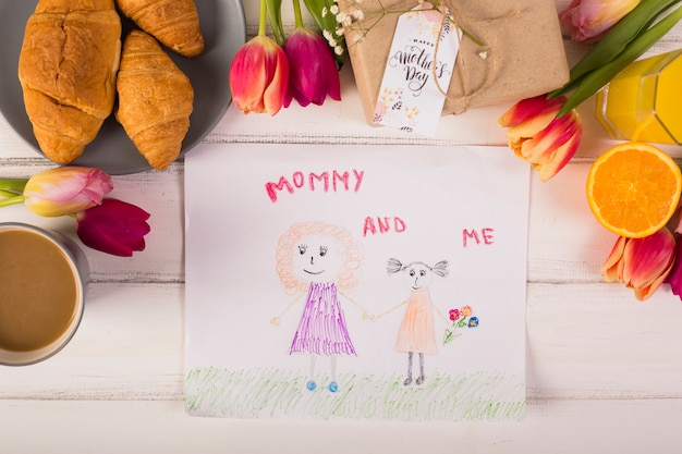 Child drawing around classic breakfast with flowers