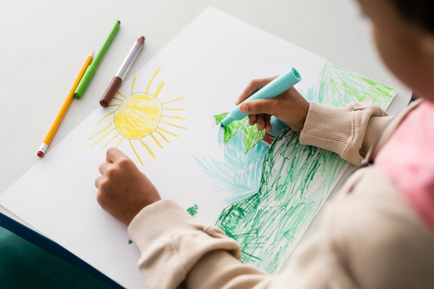 Child drawing a beautiful landscape