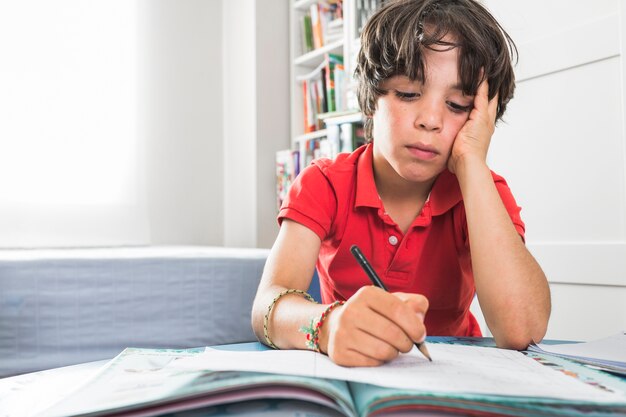 Child drawing on paper at table 