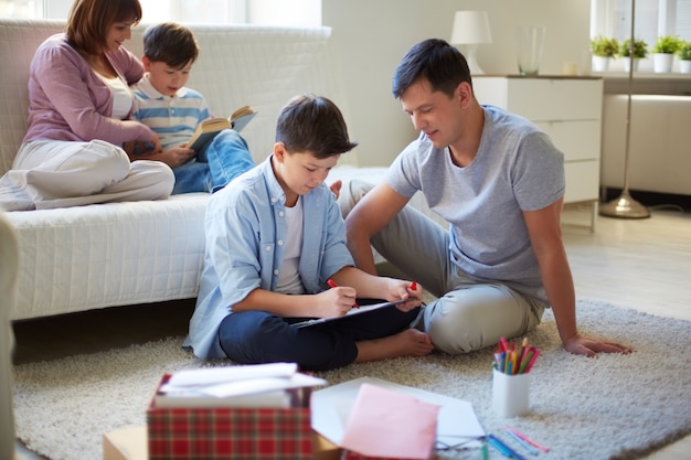 Child drawing with his family