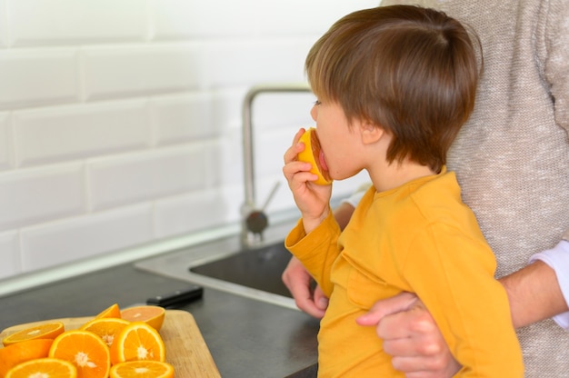 Ребенок ест оранжевый вид сбоку