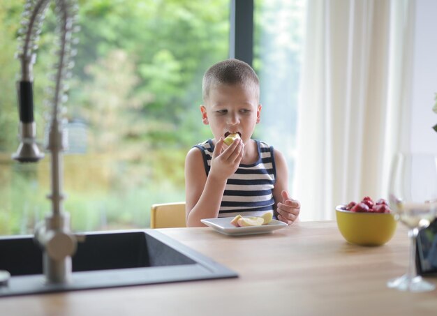 子供は台所で果物を食べる