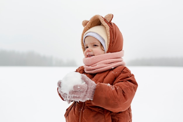 Ребенок наслаждается зимними развлечениями в снегу