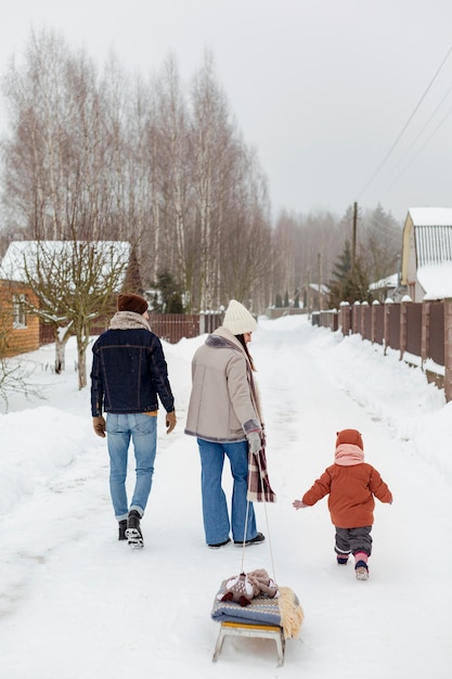 Foto gratuita bambino che si gode le attività invernali con la famiglia