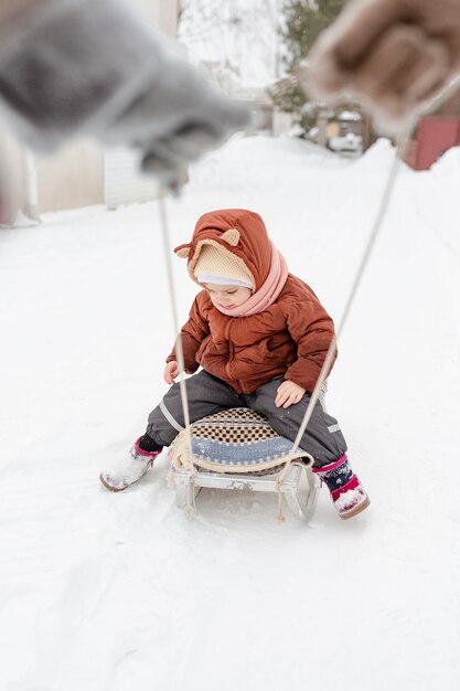 Ребенок наслаждается зимними развлечениями со своей семьей