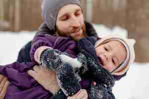 Бесплатное фото Ребенок наслаждается зимними развлечениями со своей семьей