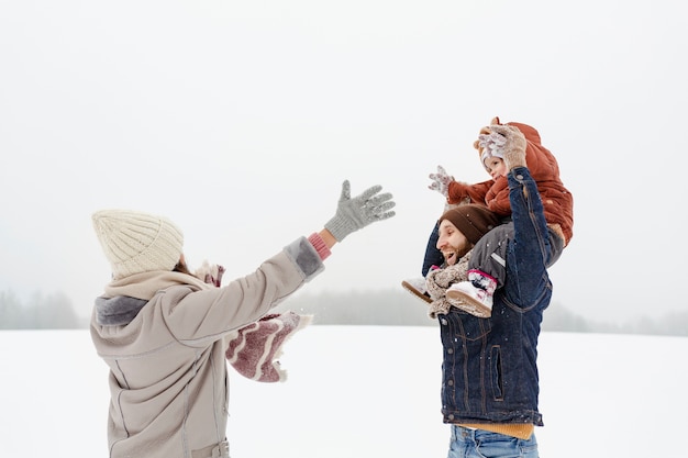 Child enjoying winter activities with their family