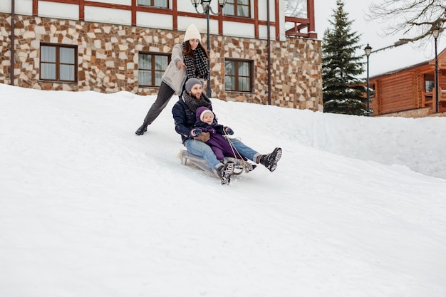 Free photo child enjoying winter activities with their family